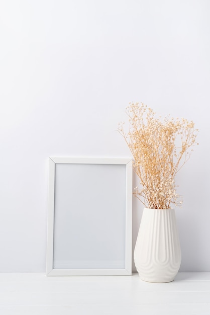 Art photo frame mockup with white vase and hypsophila flowers white background