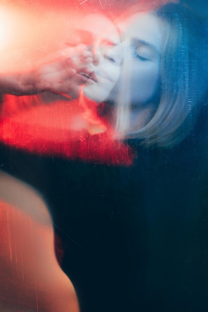 Art portrait Dream illusion Double exposure blur silhouette of peaceful woman with closed eyes in red blue bokeh light with old film dust scratches stains effect Psychedelic trance