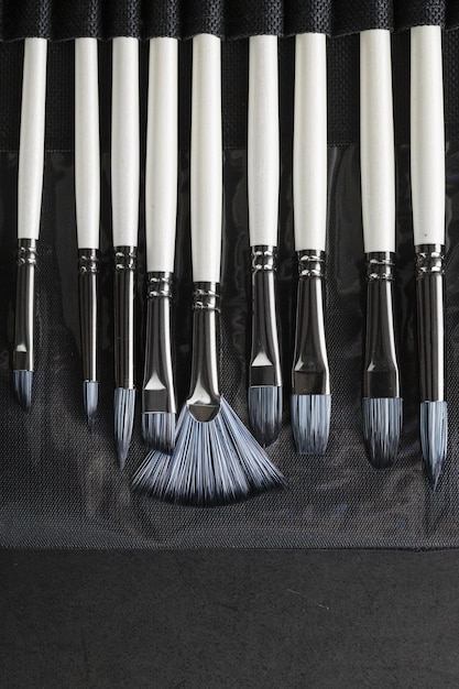 Art tools in a pencil case on a black background