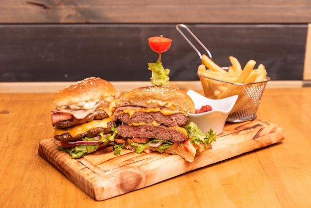 Artesanal hamburguer opened in half with fries over a wooden table