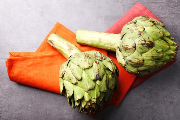 Artichokes on color wooden background