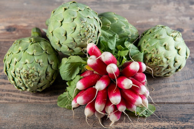 Artichokes and radishes on the wooden table