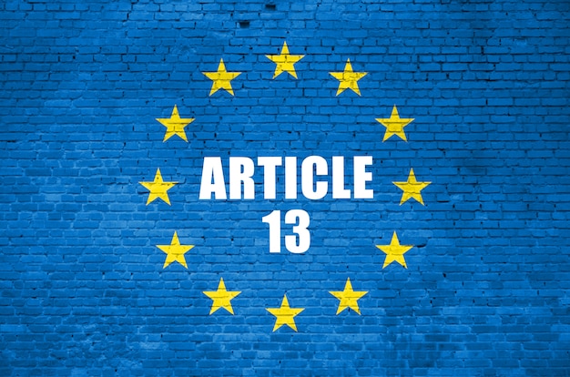 Article 13 inscription and european union flag on blue brick wall