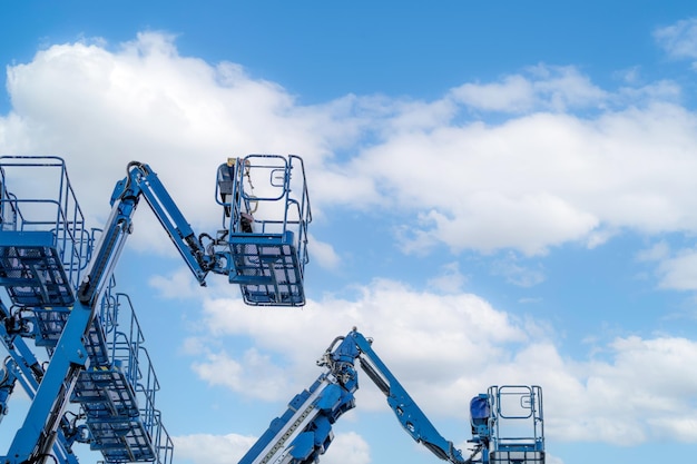 Articulated boom lift Aerial platform lift Telescopic boom lift against white cumulus clouds sky