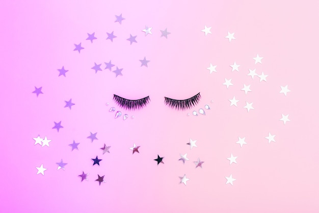 Artificial eyelashes for makeup and stars on a colorful background