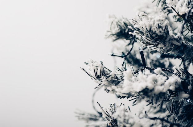 Artificial fir-tree with snow with an electric garland. 