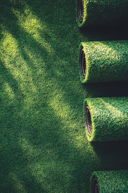 Photo artificial grass rolls lying on a green surface