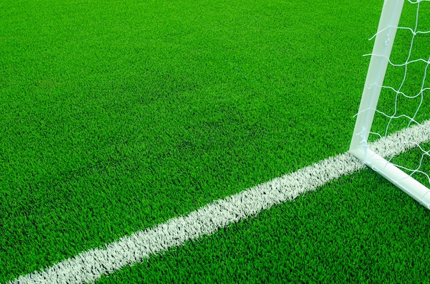 Artificial green grass with white stripes on soccer field