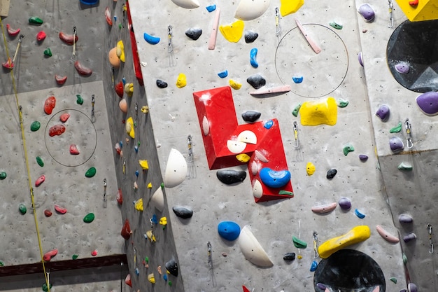 Artificial rock climbing wall with various colored grips