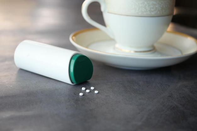 Artificial sweetener and tea cup container on table