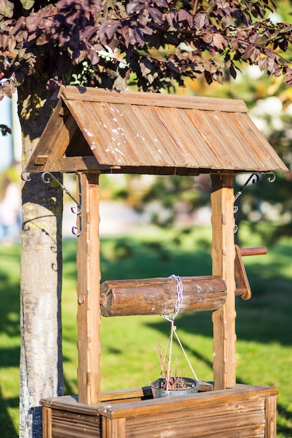 Artificial well with a bucket for flowers in the garden