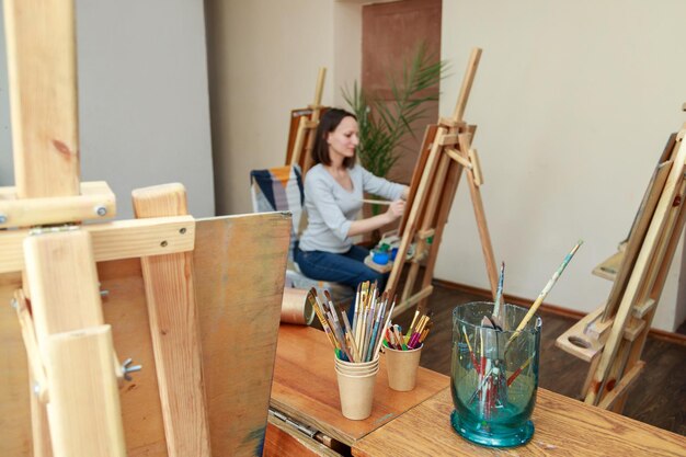 Artist draws in a classroom with easels in an art school