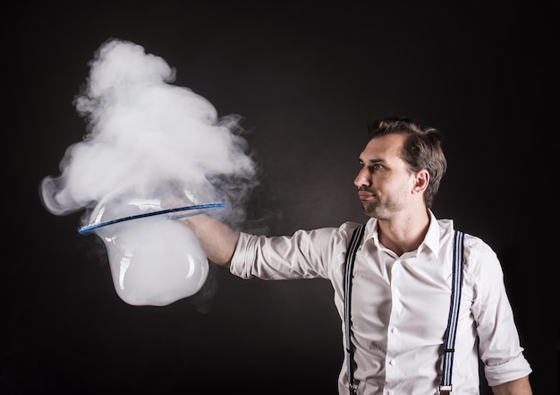 Photo artist hold big soap bubble with the smoke in his hands bubble show studio concept