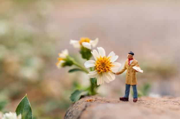 Artist holding a brush and painting flower in the garden