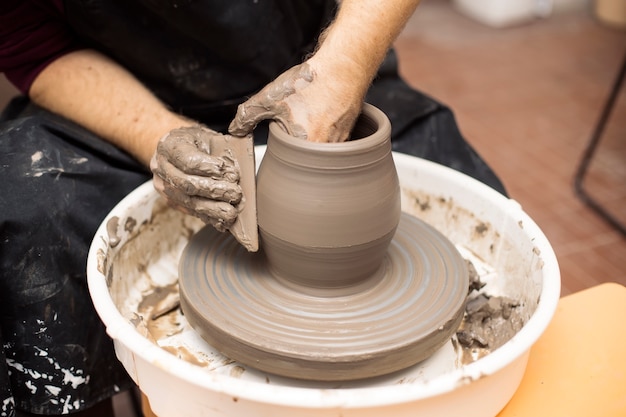 Artist makes clay pottery on a spin wheel