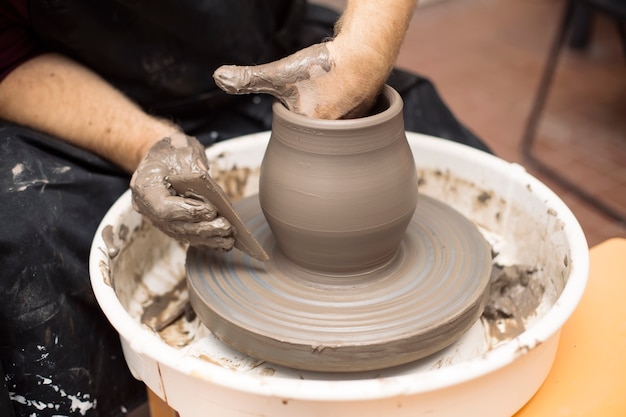 Artist makes clay pottery on a spin wheel