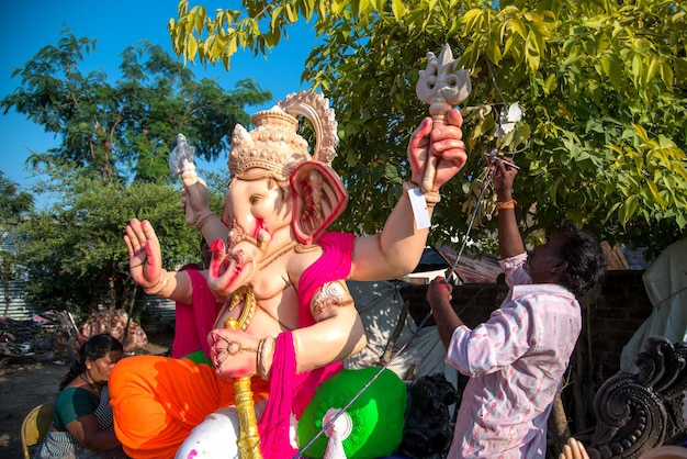 Artist making a statue and gives finishing touches on an idol of the Hindu god Lord Ganesha at an artist39s workshop for Ganesha festival