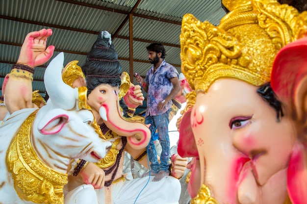 Artist making a statue and gives finishing touches on an idol of the Hindu god Lord Ganesha at an artist39s workshop for Ganesha festival