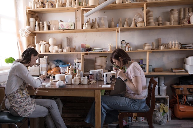 The artist's girls are engaged in coloring wooden toys for children