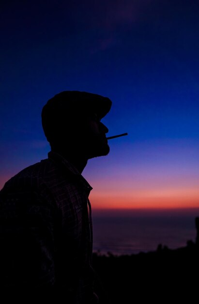 Photo artist standing against vibrant sunset on a beach