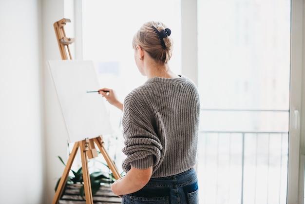 Photo artist studio interior with easel and window on the background