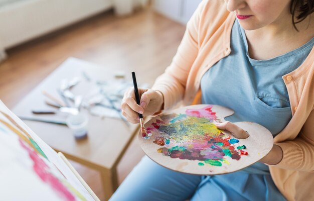 Photo artist with palette and brush painting at studio