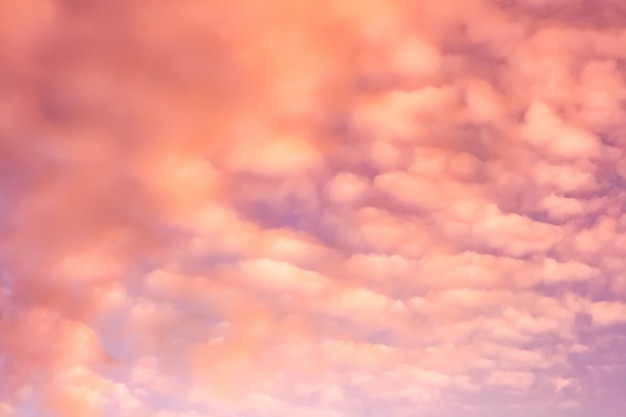 Artistic photo of sky with clouds in pink and orange colors, abstract nature background design