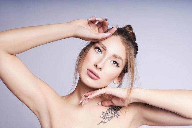 Artistic portrait of a beautiful young woman on a gray background