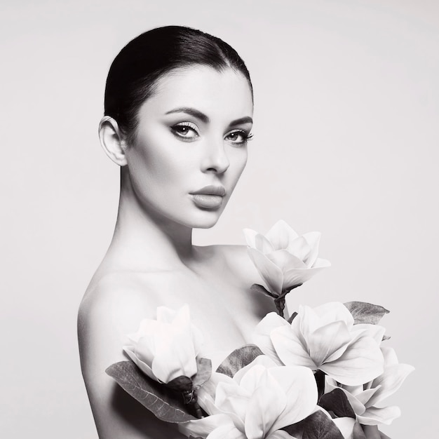 Artistic portrait of an elegant woman with beautiful flowers