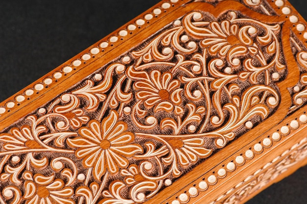 The artistic wood carving on the casket on the black background Central Asia Uzbekistan closeup