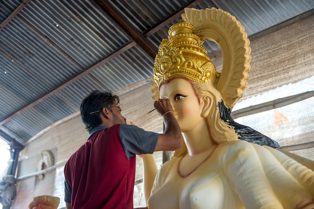 artists making and giving finishing touches on sculptures of goddess durga.