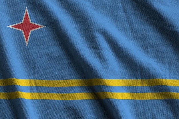 Aruba flag with big folds waving close up under the studio light indoors The official symbols and colors in banner