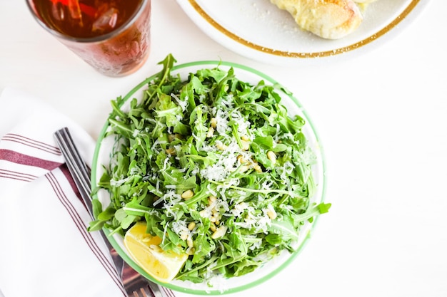 Arugula salad with pine nuts on the plate in Italian restaurant.