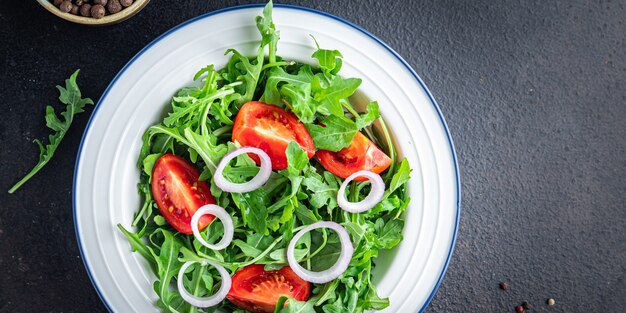 Arugula and tomato salad vegetable in a plate fresh meal snack on the table copy space food