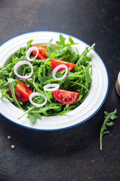 arugula and tomato salad vegetable in a plate fresh portion ready to eat meal snack on the table