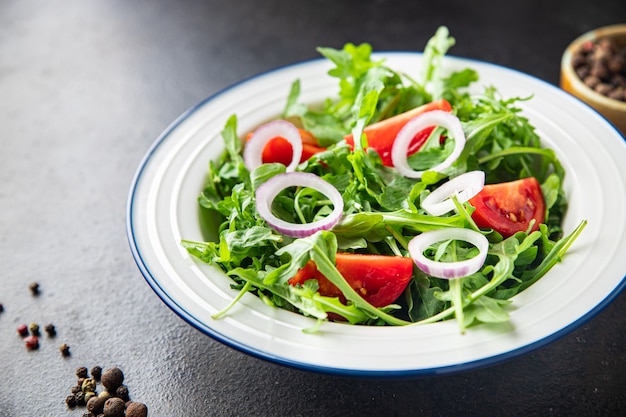 arugula and tomato salad vegetable in a plate fresh portion ready to eat meal snack on the table