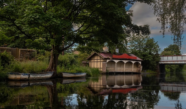 Ashley Terrace Boathouse in Edinburghs Union Canal with two old rowing boats and Lockhart bridge