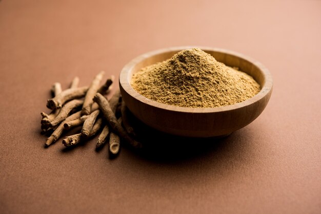 Ashwagandha or Aswaganda OR Indian Ginseng is an Ayurveda medicine in stem and powder form. Isolated on plain background. selective focus