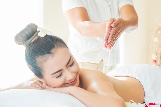 Asia beautiful woman enjoying a salt scrub massage at the health spa in Thailand