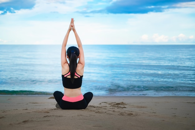 Asia beautiful woman exercising on the beach .yoga and meditation concept. 