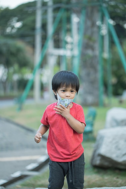 Asia child smiling playing on slider bar toy outdoor playground happy preschool little kid having funny while playing on the playground equipment in the daytime in summer