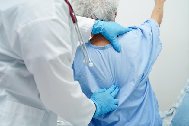 Asia doctor with stethoscope checking elderly woman patient in hospital healthy medical concept