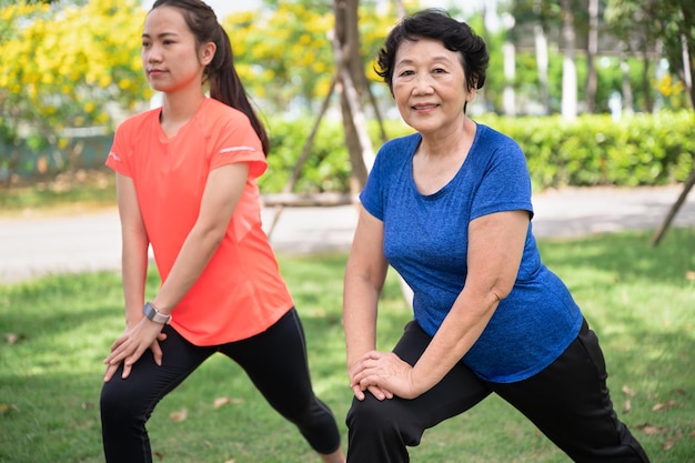 Asia senior and teenager woman training yoga at garden