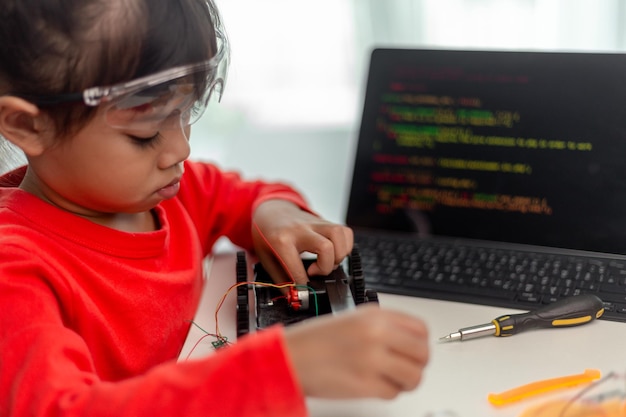 Asia students learn at home in coding robot cars and electronic board cables in STEM STEAM mathematics engineering science technology computer code in robotics for kids concept