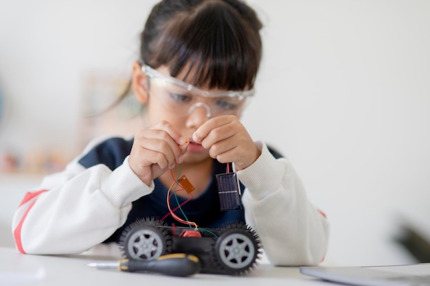 Asia students learn at home in coding robot cars and electronic board cables in STEM STEAM mathematics engineering science technology computer code in robotics for kids concept