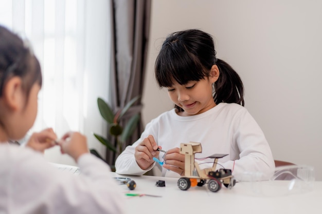 Asia students learn at home in coding robot cars and electronic board cables in STEM STEAM mathematics engineering science technology computer code in robotics for kids concept