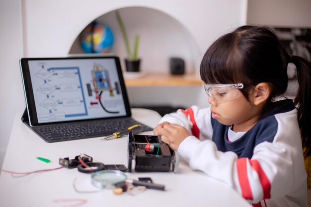 Asia students learn at home in coding robot cars and electronic board cables in STEM STEAM mathematics engineering science technology computer code in robotics for kids concept