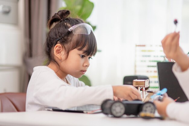 Asia students learn at home in coding robot cars and electronic board cables in STEM STEAM mathematics engineering science technology computer code in robotics for kids concept