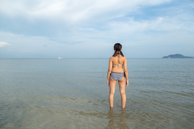 Asia teenage girls wearing bikini at the beach with copy space.