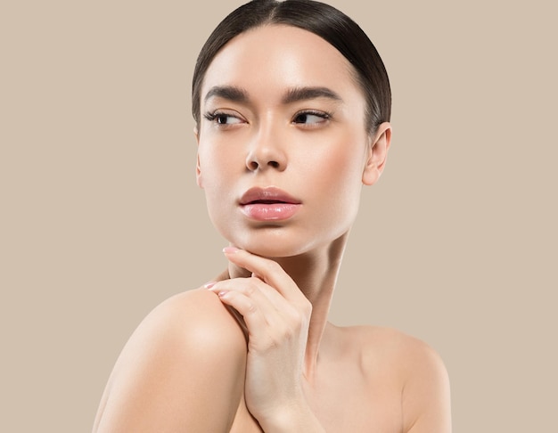 Asia woman beauty face body portrait touching her face healthy skin. Color background. Brown